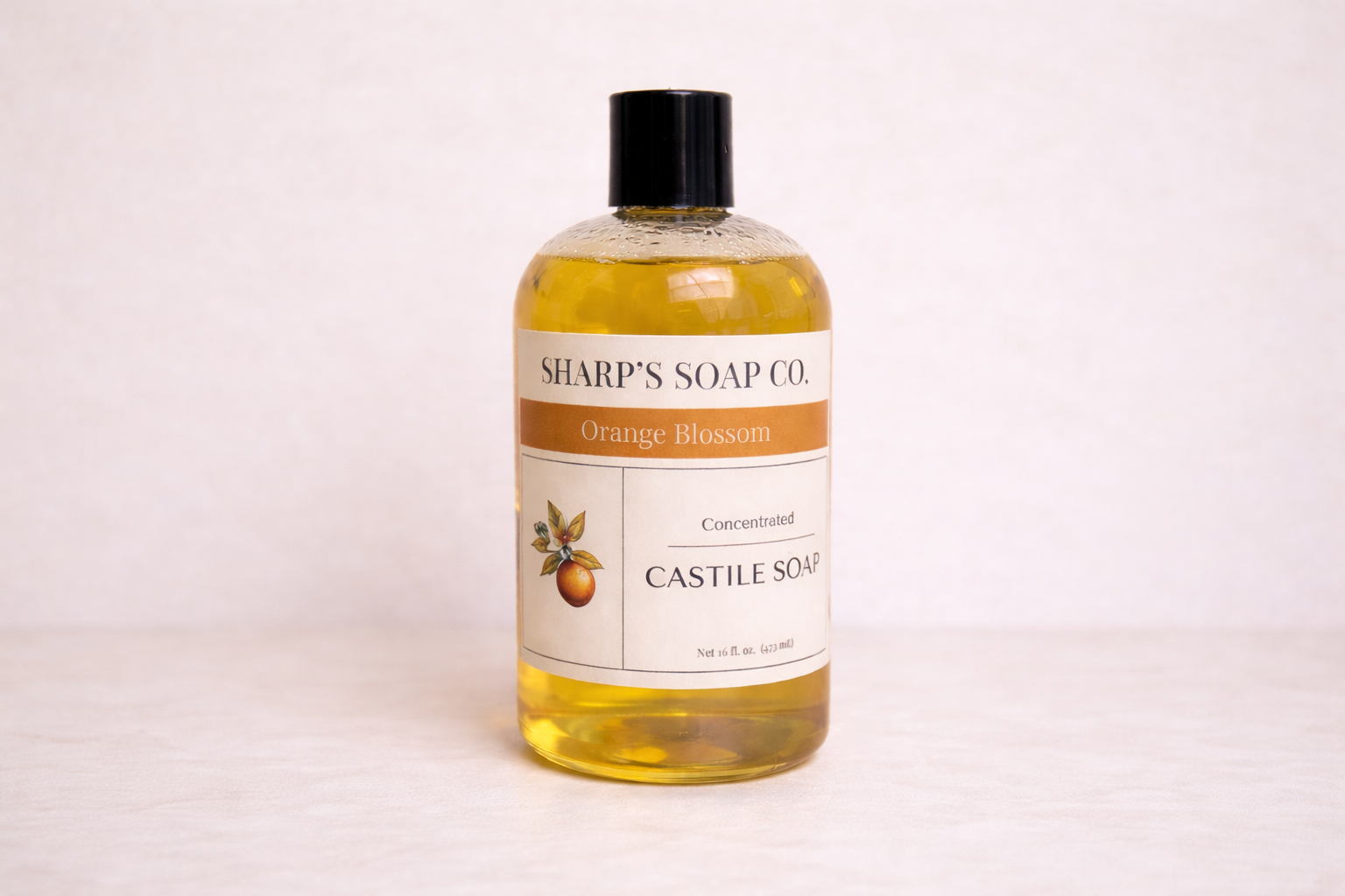 Bottle of Sharp's Soap Co. Orange Blossom Castile Soap on a white background
