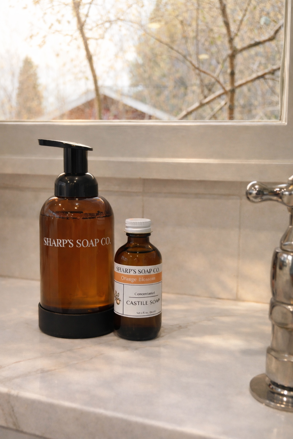 Two bottles of Sharp's Soap Co. on a bathroom counter with a window in the background.